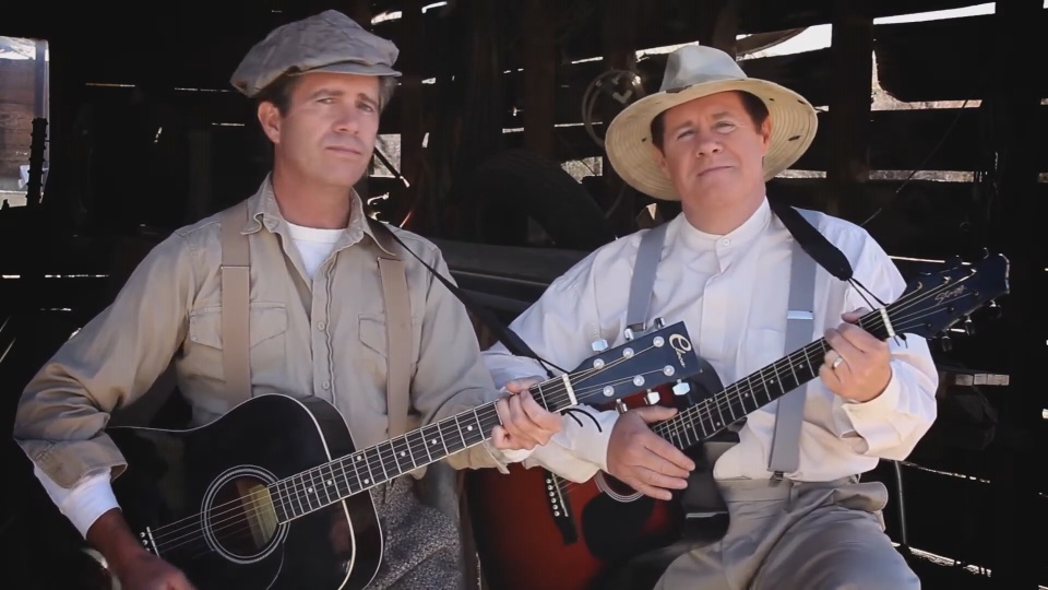 The McCain Brothers playing guitars in a rustic setting